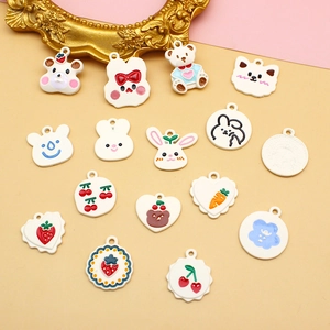 Flat lay of 15 DIY alloy charms featuring cute white animals and colorful fruit shapes