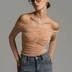 Close-up of ruched mesh fabric on a nude off-the-shoulder slim-fit long sleeve top