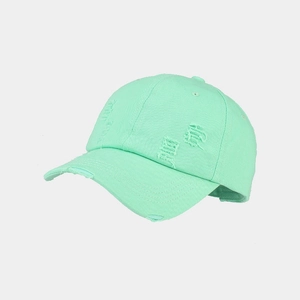 Macro detail of mint green baseball cap featuring distressed ripped edges and vintage style