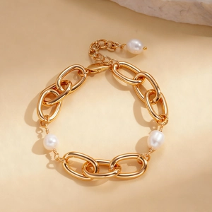 Detail of 18k gold plated chain bracelet featuring elegant white pearls and link texture