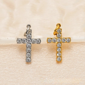 Detailed comparison of gold and silver cross pendants with crystal pavé on marble