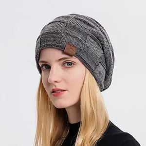 Women's dark grey winter knit beanie featuring textured patterns and leather patch