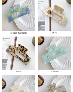 Close-up of large acetate hair claw clips in various marble and tortoiseshell patterns