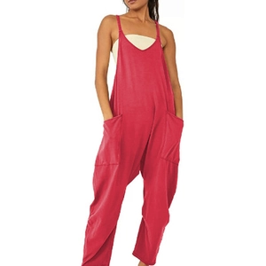 Detail of red loose jumpsuit featuring thin straps and large side pockets on bright fabric