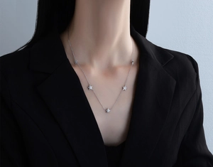 Silver S925 sterling silver star pendant necklace worn by a model in a black suit