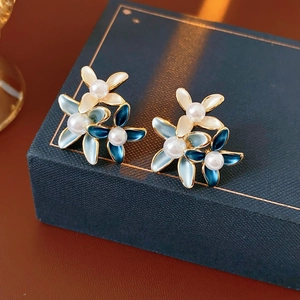 Detail of blue gradient flower earrings with gold plating and center pearl accents