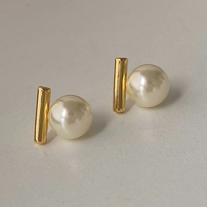 Nahaufnahme eleganter Vintage Perlenohrringe mit goldenen Stäben auf weißem Grund