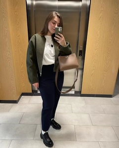 Mirror selfie showing olive green cropped jacket with navy pants and platform oxfords