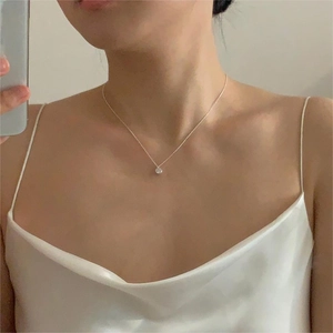 Close-up of minimalist 925 silver necklace with a sparkling round zircon pendant