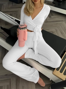 Détail de l'ensemble de yoga blanc avec haut à manches longues croisé et legging ajusté