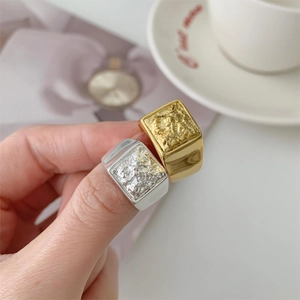 Close-up of a silver molten lava texture square ring worn on a hand in a lifestyle setting