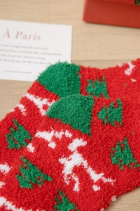 Detailaufnahme weicher Korallenvlies-Weihnachtssocken mit grünem Baum und Punktmuster