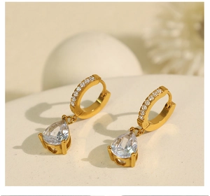 Gros plan détaillé de boucles d'oreilles dorées en forme de larme avec zircon brillant