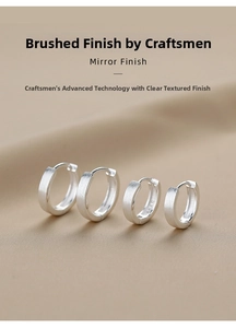 Detailed view of four S925 sterling silver brushed hoop earrings on khaki silk fabric