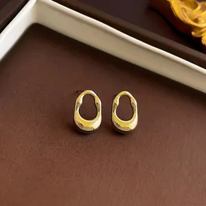Elegant gold irregular C-shape geometric earrings displayed in a luxury jewelry gift box