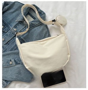 Detailed top view of beige canvas crescent bag showing size comparison with a smartphone