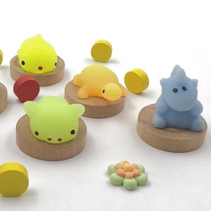 Macro shot of assorted TPR soft animal stress toys on a round wooden base display
