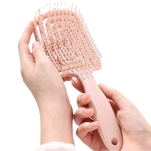 Pink curved hollow hairbrush for volume styling and scalp massage with round tips