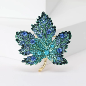 Detailed close-up of maple leaf brooch with vibrant blue and green rhinestones