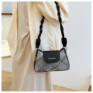 Close-up of grey denim texture and black leather shoulder bag with floral silver chain