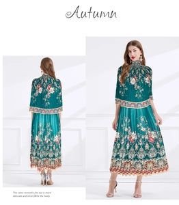 Detail of dark green pleated floral dress featuring a high collar and long sleeves