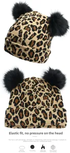 Detail showing highly elastic leopard print knit beanie with double black faux fur pom-poms