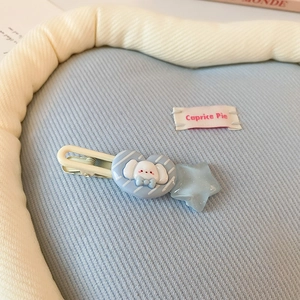 Gros plan d'une pince à cheveux bleue avec un cœur de chiot mignon et une étoile brillante