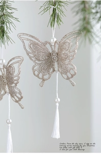Close-up of champagne gold glitter butterfly ornament with pearls and silk tassel