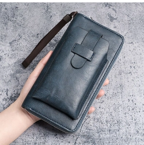 Detail of navy blue long leather wallet featuring front buckle pocket and wrist strap
