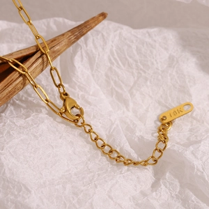 Detail of 18K gold-plated star moon necklace showing lobster clasp and 18K hallmark tag