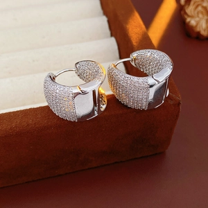 Close-up of silver C-shaped hoop earrings with shimmering pavé cubic zirconia detail