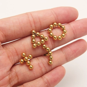 Golden beaded earrings set featuring round, triangle, and cross shapes in polished steel