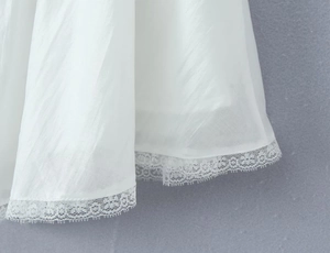 Detailed macro view of white chiffon fabric with delicate eyelash lace edge trim