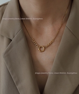 Detail of 18K gold-plated asymmetrical chain necklace with irregular geometric ring pendant