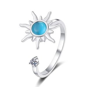 Rotating silver ring with blue cat-eye stone and white zircon detail on white background