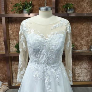 Detail of delicate lace appliques on a white long-sleeved bridal wedding gown