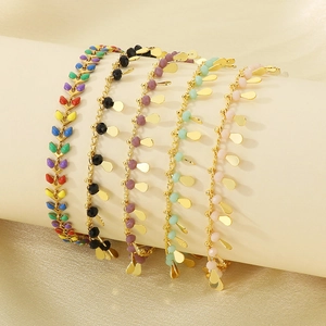 Colorful fish tail anklets with gold beads and leaf charms on soft beige silk