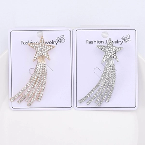 Detailed view of silver and gold rhinestone star brooches with cascading tassel trails