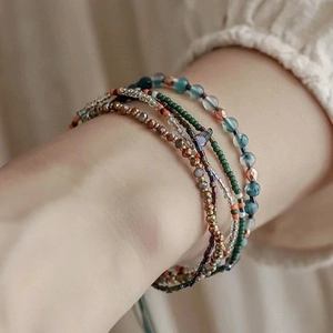 Bohemian multi-layer seed bead bracelet featuring blue, green, and copper glass stones