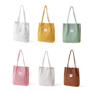 Vista detallada de seis bolsos tote de pana en varios colores con textura rugosa