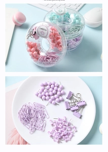Vue macro des trombones et pinces macaron violet et rose dans une boîte de rangement claire