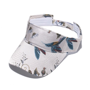 Detailed view of sun visor with hummingbird and floral print faux silk fabric