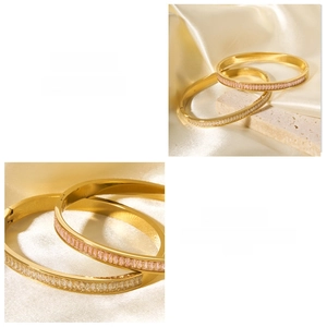 Close-up of gold stainless steel bangle set with white and pink cubic zirconia stones