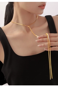 Detail of adjustable gold snake chain necklace showing sliding ball clasp on model