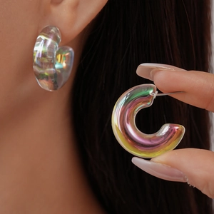 Detailed view of holographic acrylic C-shaped earrings showing colorful light refraction