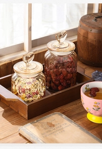 Detail of amber glass storage jars with heart-shaped lids and textured patterns on a tray