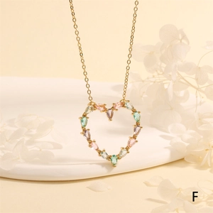 Detailed macro view of the hollow heart pendant with multi-colored crystals on a gold chain