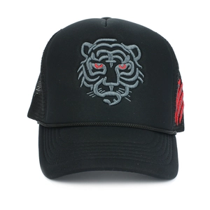 Detail of tiger head embroidery and red claw marks on black mesh trucker cap