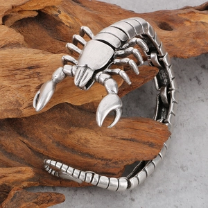 Detailed view of silver scorpion bracelet with vintage finish on stone and wood