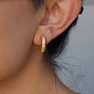 Close-up of 14K gold plated stainless steel triple-layer hoop earring on model ear